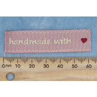 Tag, pink, white printed wording "handmade with " with  red heart symbol