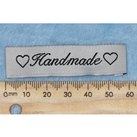 Tag, cream, black embroidered wording "Handmade " with 2 heart symbols