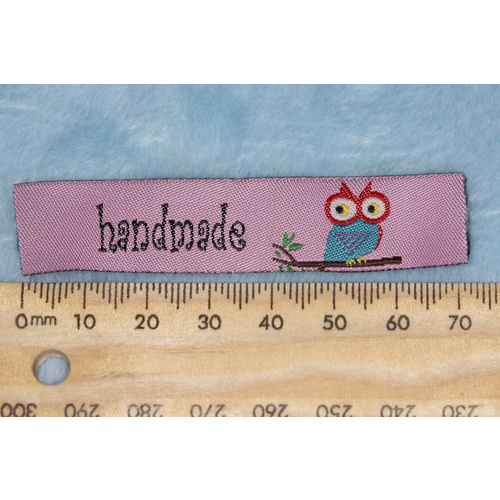 Tag, pink, black embroidered wording "handmade " with colourful bird on branch symbol