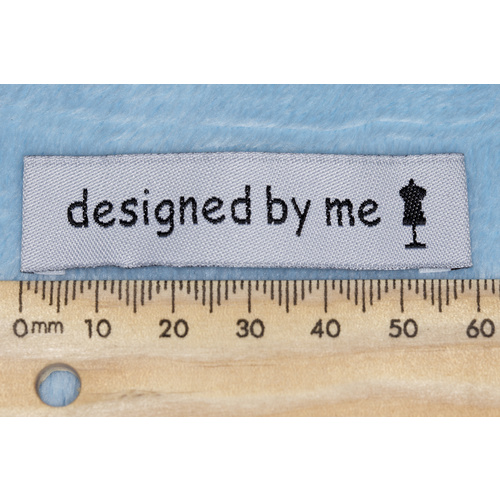 Tag,white, black embroidered wording "designed by me " with dress maker dummy symbol