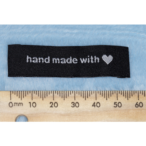 Tag, black with white embroidered  wording "hand made with" with heart symbol